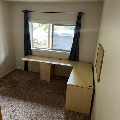Sale Photo Thumbnail #40: Large L-shaped light wood laminate office desk featuring a built-in two-drawer filing cabinet and integrated cable management grommets.
