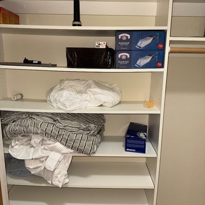 Sale Photo Thumbnail #42: White laminate closet shelving unit holding various household items, including linens, blankets, a Birkenstock box, and Brybelly blackjack dealer shoes.