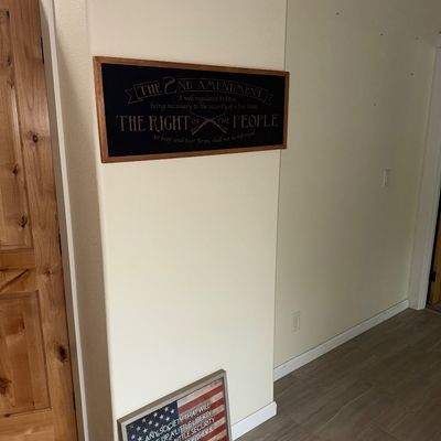 Sale Photo Thumbnail #39: Two patriotic wall art pieces, including a framed black sign featuring the text of the Second Amendment and a smaller framed American flag sign with a Benjamin Franklin quote.