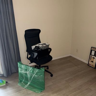 Sale Photo Thumbnail #36: Black mesh ergonomic office chair on casters, shown with a bubble-wrapped flat item and miscellaneous office accessories.