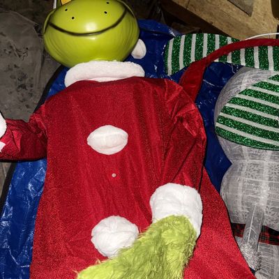 Sale Photo Thumbnail #47: 9 ft Life-size animated Grinch Christmas decoration in a Santa suit, shown lying flat on a blue tarp.