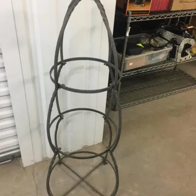 Wrought iron garden obelisk trellis featuring a crown finial and three tiers for climbing plants.