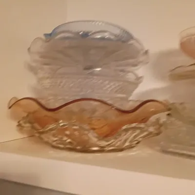 Sale Photo Thumbnail #42: Stack of vintage pressed glass and carnival glass ruffled dishes on a shelf.