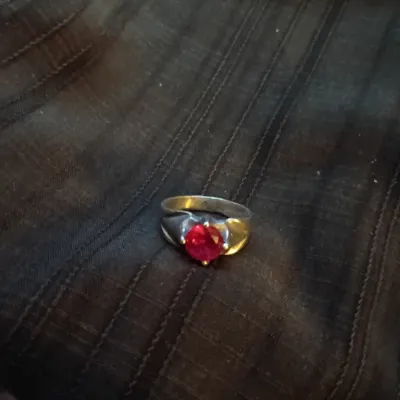 Vintage silver-tone ring set with a faceted round red glass stone or synthetic gemstone.
