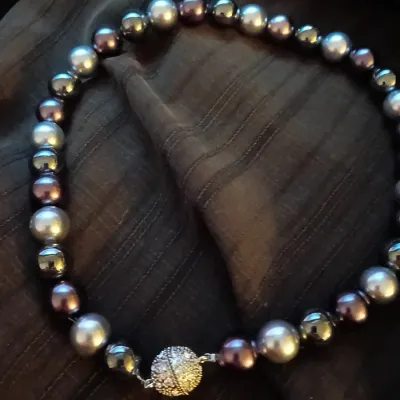 Strand of multi-toned Tahitian-style faux pearls featuring bronze, silver, and dark metallic beads, secured with a rhinestones-pave...