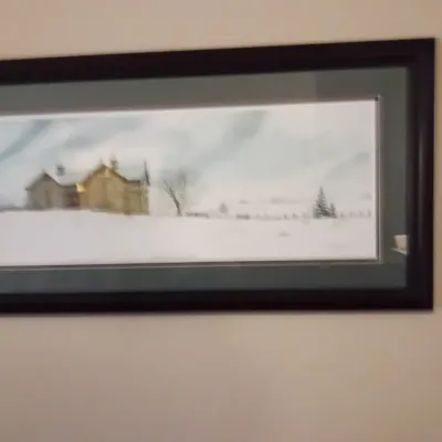 Sale Photo Thumbnail #60: Framed panoramic landscape print depicting a snowy rural barn scene, set in a dark wood frame with a green double mat.