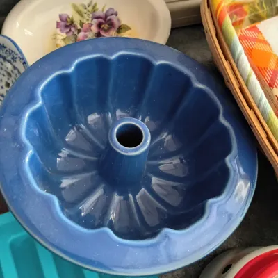 Sale Photo Thumbnail #2: Cobalt blue glazed ceramic Bundt cake pan shown alongside other assorted kitchenware and dishes.