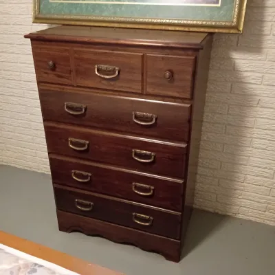 Sale Photo Thumbnail #63: Traditional dark wood tall chest of drawers with brass bale handles and decorative top drawer detail.