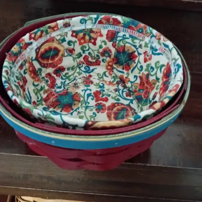 Sale Photo Thumbnail #13: Round Longaberger-style woven basket featuring a painted red finish with blue trim, complete with a quilted floral fabric liner.