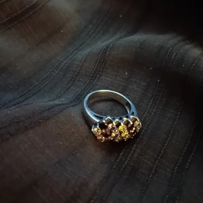 Silver-tone cocktail ring featuring a cluster of pave-set multicolor yellow and dark stones.