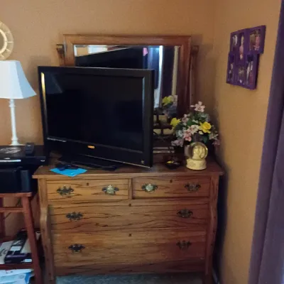 Sale Photo Thumbnail #49: Traditional oak dresser with attached mirror, brass hardware, and a modern flat-screen television sitting on top.