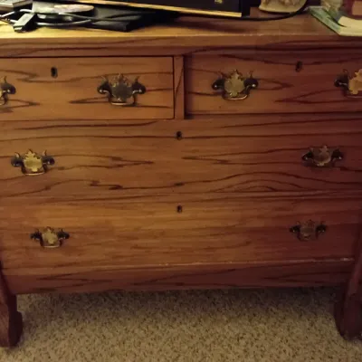 Sale Photo Thumbnail #23: Traditional oak dresser with ornamental brass bail handles and keyholes, featuring curved legs and two small upper drawers over two full-width drawers.