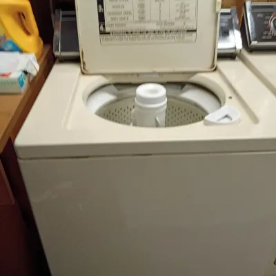 Sale Photo Thumbnail #31: Vintage top-loading automatic washing machine in almond finish, showing open lid with printed operating instructions.