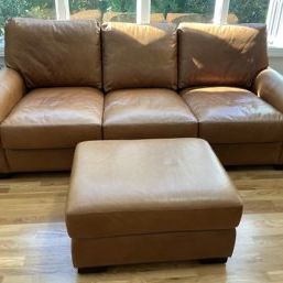Sale Photo Thumbnail #4: Pottery Barn camel leather three-cushion sofa with rolled arms, paired with a matching square leather ottoman.