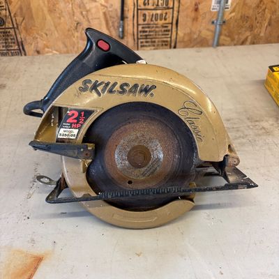Sale Photo Thumbnail #17: Vintage Skilsaw Classic 2-1/2 HP circular saw, model 5250:05, featuring a gold housing and a rusted blade.