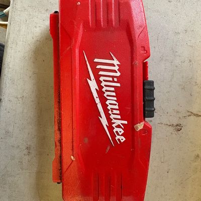 Sale Photo Thumbnail #4: Milwaukee red plastic tool accessory case with a black sliding latch, showing some wear and dirt from use.