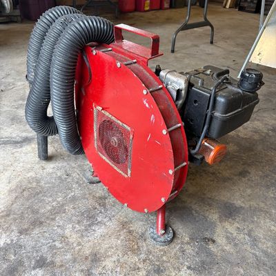 Sale Photo Thumbnail #53: Gas-powered portable blower machine with a red housing and dual flexible corrugated hoses, showing light cosmetic wear.