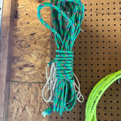 Sale Photo Thumbnail #18: Neatly bundled green, blue, and red patterned utility rope hanging on a pegboard.