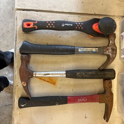Sale Photo Thumbnail #16: Assortment of hand tools including three claw hammers with varying degrees of surface rust and a Red Devil paint scraper.