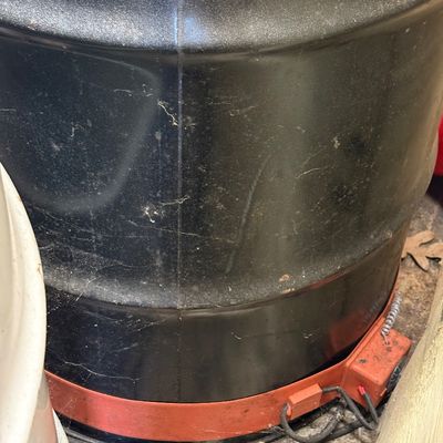 Sale Photo Thumbnail #58: Heavy-duty black plastic drum fitted with an orange silicone band heater at the base, showing some dust and wear from storage.
