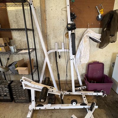Sale Photo Thumbnail #68: Body-Solid white metal home gym frame with pulley system, showing some wear and disassembled parts.