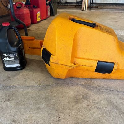 Sale Photo Thumbnail #9: Stihl chainsaw in a yellow hard-plastic carrying case, paired with a one-gallon jug of ProSelect Premium bar and chain oil.