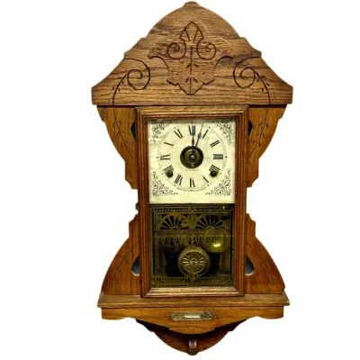 Sale Photo Thumbnail #26: Antique carved oak gingerbread wall clock featuring a Roman numeral dial, decorative brass pendulum, and gold stencil glass door, circa late 19th to early 20th century.