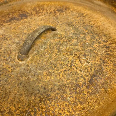 Sale Photo Thumbnail #589: Heavy rust-covered cast iron Dutch oven lid stamped with a size 14.