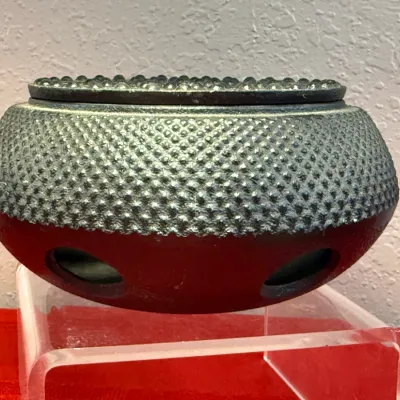 Sale Photo Thumbnail #467: Cast iron hobnail teapot warmer featuring a textured, dimpled upper body and ventilation cutouts along the smooth lower base.