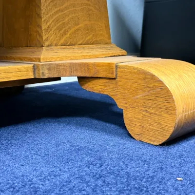 Sale Photo Thumbnail #684: Detailed view of the quarter-sawn oak pedestal base and scroll foot of an antique table.