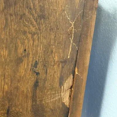 Sale Photo Thumbnail #283: Close-up detail of a wooden furniture piece, showing wear, scratches, and damage to the finish.