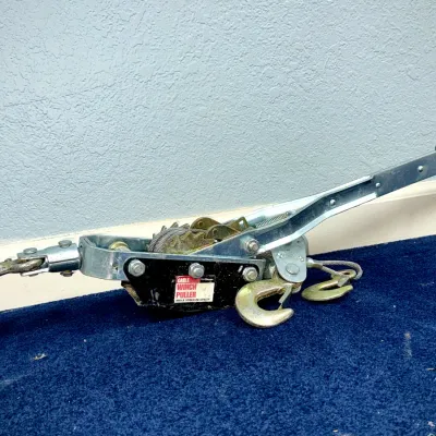 Sale Photo Thumbnail #654: Heavy-duty 8,000 lb. double-line capacity cable winch puller with ratchet mechanism and steel safety hooks.