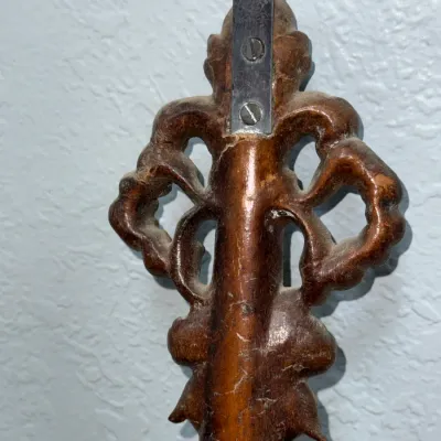 Sale Photo Thumbnail #398: Back view of a carved wooden decorative piece or frame top, featuring ornate scrollwork and a metal hanging bracket.