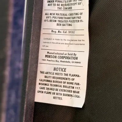 Sale Photo Thumbnail #296: Manufacturer's law tag on upholstered furniture from Minson Corporation, listing materials and California flammability compliance.