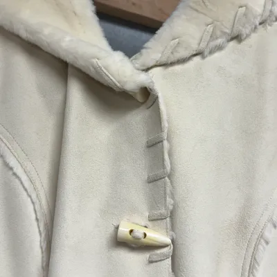 Sale Photo Thumbnail #847: Off-white faux suede and shearling winter coat featuring toggle buttons and decorative whipstitching along the trim.