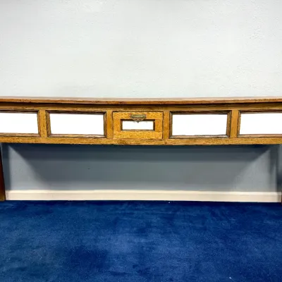 Sale Photo Thumbnail #290: Antique wooden console table featuring white-framed panel fronts, a central drawer with brass hardware, and turned legs.