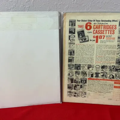 Sale Photo Thumbnail #778: Two vintage comic books in protective plastic sleeves showing a backing board and a vintage music club advertisement on the reverse.