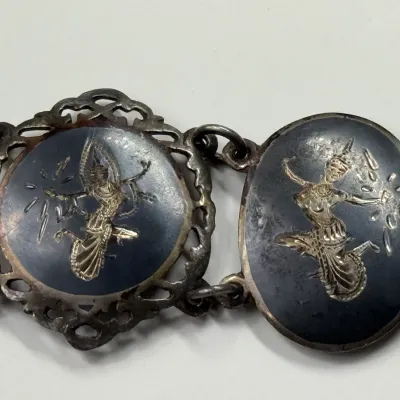 Sale Photo Thumbnail #164: Vintage Siam sterling silver niello panel bracelet featuring detailed depictions of Thai dancers, showing mild surface wear and patina.