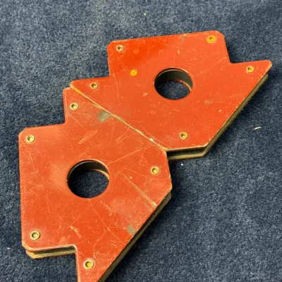 Sale Photo Thumbnail #505: Pair of red magnetic arrow welding holders showing light surface scuffs and wear from use.