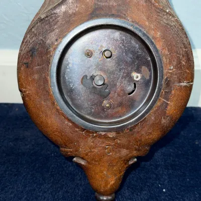 Sale Photo Thumbnail #399: Back view of a vintage carved wooden clock housing, showing the metal mechanical clock movement casing and adjustment knobs.