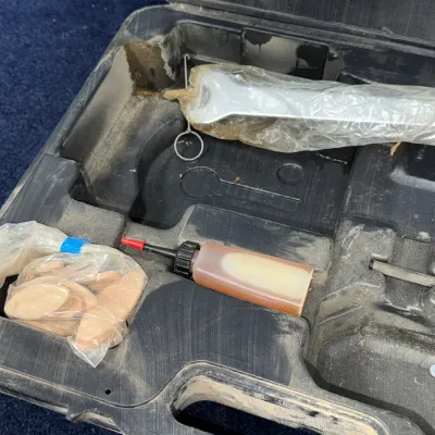Sale Photo Thumbnail #628: Open plastic tool case containing wood biscuits, a small oil bottle, and a wrapped wrench, showing signs of dusty workshop use.