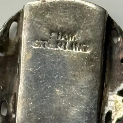Sale Photo Thumbnail #169: Close-up detail of a vintage jewelry clasp showing 14K and STERLING hallmarks stamped on tarnished metal.