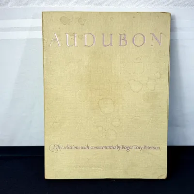 Sale Photo Thumbnail #32: Vintage hardcover book titled Audubon's Birds of America with commentaries by Roger Tory Peterson, featuring a cloth-bound cover with visible age staining.