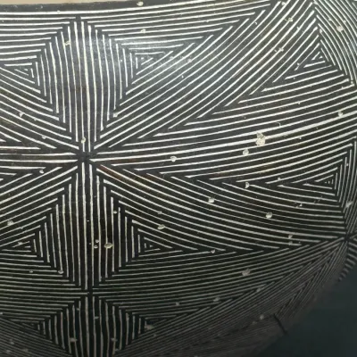 Sale Photo Thumbnail #131: Close-up of a Southwest-style ceramic pot featuring intricate black-and-white geometric fine-line patterns with minor surface wear.