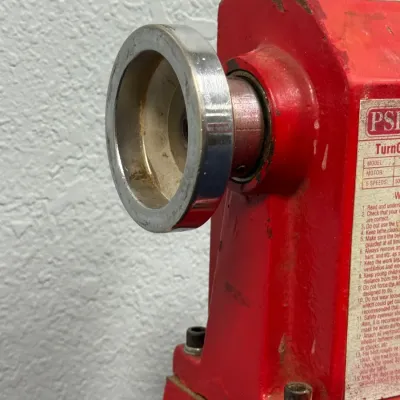 Sale Photo Thumbnail #554: Close-up detail of a red PSI Turncrafter woodworking lathe showing the handwheel and safety instruction label.