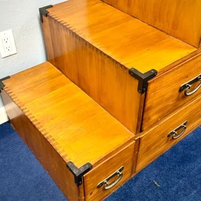 Sale Photo Thumbnail #208: Japanese-style kaidan tansu step chest in warm honey wood with dovetail joinery, metal corner brackets, and drop-handle pulls.