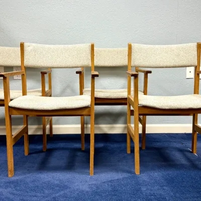 Sale Photo Thumbnail #689: Set of four Danish mid-century modern oak armchairs featuring neutral textured fabric upholstered seats and backrests.
