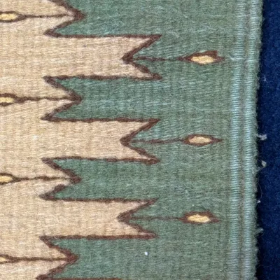 Sale Photo Thumbnail #427: Detail view of a flat-weave wool Southwest-style runner rug, featuring green, tan, and terracotta geometric motifs.