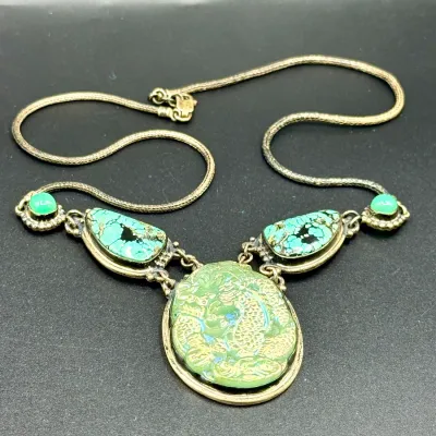 Sale Photo Thumbnail #325: Vintage Asian-inspired statement necklace featuring a carved green dragon center pendant flanked by turquoise stones on a mesh chain.