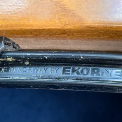 Sale Photo Thumbnail #237: Detail view of the manufacturer's label reading 'MADE IN NORWAY BY EKORNES' on a wooden furniture frame.